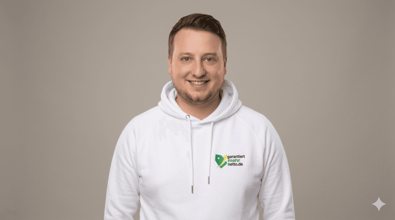 Porträt eines lächelnden Mannes im weißen Hoodie mit Firmenlogo vor einem neutralen Hintergrund.
